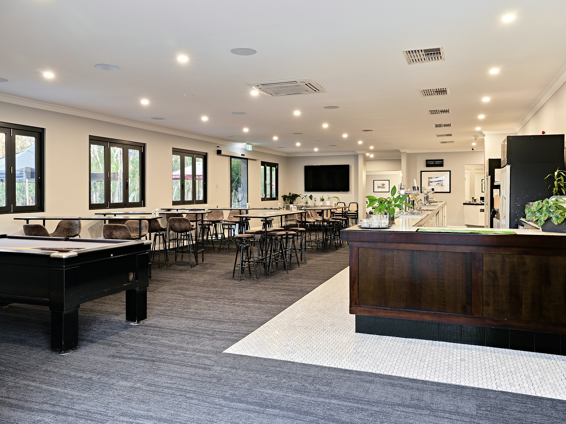 A large room with a pool table and a bar